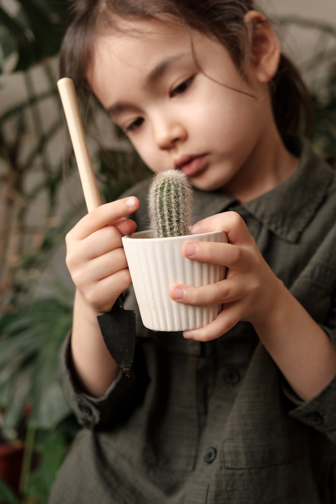 Kid Holding a Cactus